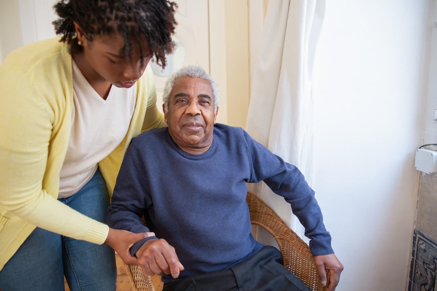 Caregiver attending to elderly patient at home
